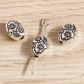 Macro view of vintage silver sunflower embossed beads for DIY jewelry making - Oval Floral Style / 50 Pieces / Antique Silver