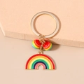 Dettaglio di un portachiavi arcobaleno in lega dorata con ciondolo smaltato e perline - Stile Arcobaleno Rotondo