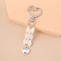 Detail of silver heart clasp and pearl bow keychain on minimalist warm beige background - Silver Bow Knot Heart