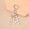 Detail of silver heart keychain with elegant white pearls and a delicate bow charm - Silver Bow Knot Heart