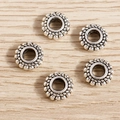 Macro detail of five vintage silver alloy spacer beads with textured dot pattern on wood - Flat Round Dotted Style / 50 Pieces / Antique Silver
