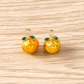 Detailed close-up of handmade orange fruit pendants with green leaves for DIY jewelry crafts - 5 Pieces / Orange