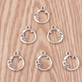 Close-up of six crescent moon and star alloy pendants on a rustic wood background - Silver Moon