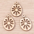 Macro shot of three teardrop-shaped wooden pendants with hollow floral carvings for DIY - 10 Pieces Pack / Flower Water Drop