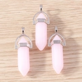 Detailed macro view of three pink hexagonal crystal bullet pendants with silver metal caps - 5 Pieces / Pink