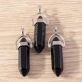 Macro detail of three hexagonal black obsidian bullet pendants with silver metal clasps - 5 Pieces / Black