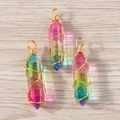 Set of crystal bullet pendants with wire wrapped golden wire on wood background - Colorful