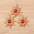 Three gold sun pendants with red gemstones for DIY jewelry making on wood surface - 10 Pieces Pack / Red