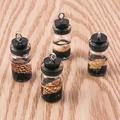 Primer plano de colgantes de botellas de vidrio con tema oceánico, conchas y aros de metal - Negro