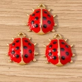 Three red ladybug pendants with black dots and golden metal finish for DIY jewelry - 10 Pieces Pack / Red Ladybug