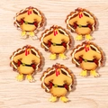Flat lay of six cartoon cowboy turkey acrylic pendants for Thanksgiving DIY jewelry crafts - Akimbo Turkey