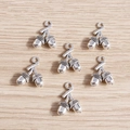 Five antique silver alloy double acorn pendants on light wood background for DIY jewelry - Pinecone Style