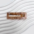 Pince à cheveux rectangulaire marron marbré avec base en métal doré sur un plateau - Couleur caramel