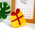 Christmas gift box hair claw clip in yellow with red bow decoration in lifestyle setting - Gift Box