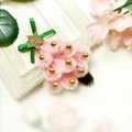 Pink plush Christmas tree hair clip with golden star and beads on white wood surface - Pink