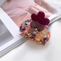 Pinza per capelli in acetato con fiore viola e logo dorato su sfondo di rivista alla moda - Fiore Viola