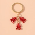 Detailed view of 3D red spider pendants with gold metallic key ring and chain - Red