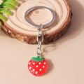 Portachiavi a forma di fragola 3D con foglia verde su sfondo di legno naturale - Fragola