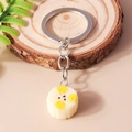 Realistic artificial pear fruit keychain with silver metal ring on a natural wooden background - Banana Slice