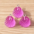 Gros plan de trois pendentifs cœur en résine magenta translucide avec anneaux métalliques - Coquille Spirale / Lot de 10 / Violet