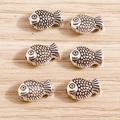 Macro detail of six retro silver fish charms for DIY jewelry making on wood - Fish / 40Pcs Pack / Antique Silver