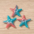 Detail view of resin starfish charms with pink to cyan gradient and pearl dot texture - Navy Blue and Red