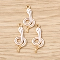 Detail of three golden snake pendants with white enamel for DIY jewelry making - White