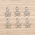 Set mit sechs silbernen Sternanhängern mit gelben Strasssteinen auf Holzuntergrund - Sternform / 10er Pack / Silber