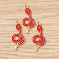 Detailed macro view of red enamel snake charms with gold plated alloy finish for DIY jewelry - Red