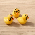 Detailed view of yellow resin 3D duck charms with silver rings for DIY jewelry making - Black Helmet Large Duck Style