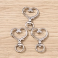 Tre fermagli a moschettone a forma di cuore d'argento con anelli rotanti su legno chiaro - Chiusura Pendente Cuore Argento / Confezione da 10