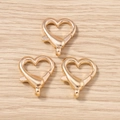 Dettaglio di moschettoni a forma di cuore dorati con meccanismo a molla su legno - Oro Cuore / Confezione da 10