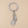 Silver metal keychain featuring detailed hedgehog and pineapple fruit charms on ring - Silver