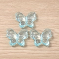 Three pieces of light blue transparent butterfly pendants for DIY jewelry on wood background - 5 Pieces / Blue
