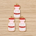Detailed macro view of pink and white enamel medical bottle charms with gold plating finish - 10 Pieces Pack / Poison Bottle