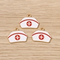 Macro detail of three alloy nurse hat charms with red cross on light wood texture - 10 Pieces Pack / Nurse Hat