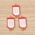Détail de trois pendentifs en émail en forme de poche de sang sur fond bois clair - Lot de 10 / Style Petits Bits