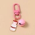 Detail of pink nurse hat keychain with bell and small medicine bottle charm accessory - Poison Bottle