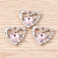 Dettaglio di tre ciondoli a cuore con gemma rosa e montatura in metallo argento martellato - Set di 4 / Rosa argento