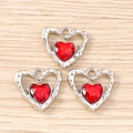 Macro detail of red heart-shaped gemstone pendants with silver textured metal frames - Silver Red