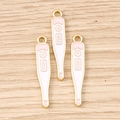 Vue macro de trois pendentifs thermomètres dorés en émail avec inscription 37.0°C - Lot de 10 / Thermomètre Rose