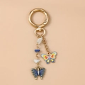 Detail eines goldenen Schmetterling Schlüsselanhängers mit Emaille und Perlen verzierung - Blauer Schmetterling