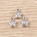 Three silver star pendants with sparkling rhinestones on light wood background - Silver Rhinestone Small Star / 5 Pieces