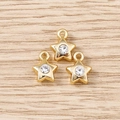 Macro shot of three star-shaped gold pendants with clear rhinestones on wood - Gold Rhinestone Small Star / 5 Pieces
