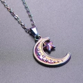 Rainbow plated stainless steel moon and star pendant necklace on a textured dark base - Pendant Necklace / Rainbow
