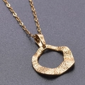 Detailed close-up of a gold irregular ring pendant with a hammered lava texture finish - Necklace / Gold