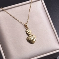 Vue détaillée du pendentif Cœur Sacré en acier inoxydable plaqué or 18 carats avec flamme - Collier pendentif / Or