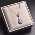 Détail d'un pendentif cœur arc-en-ciel avec épines sur un coussin de bijouterie doré - Collier pendentif / Couleur AB