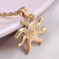 Macro view of a 18k gold-plated sun pendant necklace with detailed spiral patterns - Necklace / Gold