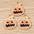Détail macro de trois pendentifs citrouille d'Halloween en émail orange et alliage doré - Lot de 10 / Orange Doré
